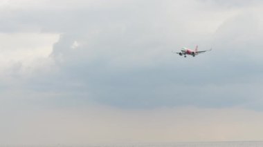 PHUKET, THAILAND - 27 Kasım 2019: Phuket havaalanına inmeden önce sivil uçak Airbus A320 AirAsia yaklaşıyor. Uçak sinekleri için uzak bir ihtimal. Turizm ve seyahat kavramı