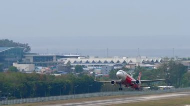PHUKET, THAILAND - Şubat 06, 2023: Airbus A320, AirAsia 'nın HS-CBD' si Phuket havaalanından kalkıyor, yan görüş. Jet uçağı kalkıyor, tırman. Uçak kalkıyor.