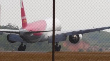 PHUKET, THAILAND - 18 Şubat 2023: Geniş gövdeli Boeing 777, Pegas Fly 'ın RA-73272' si, Phuket havaalanına iniş ve frenleme, sinematik çekim. Turizm ve seyahat kavramı