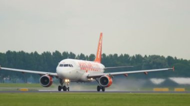 AMSTERDAM, NETHERLANDS - 24 Temmuz 2017: görüntülü Airbus A320, kolay jetin G-EZUL kalkışı, Amsterdam Havalimanı 'na tırmanma. Jetin kalkışının yan görüntüsü. Turizm ve seyahat kavramı