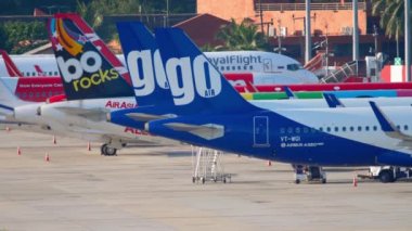 PHUKET, THAILAND - 27 Kasım 2019: Havaalanındaki yolcu uçakları kalkıştan önce veya inişten sonra serviste. Sıraya dizilmiş uçak kuyruğu. Seyahat havacılık kavramı