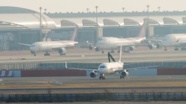 BANGKOK, THAILAND - 21 HAZİRAN 2023: Airbus A320, HS-TXF Thai Smile Bangkok, Suvarnabhumi Havaalanı 'ndaki havaalanında taksicilik. Uçaklar terminale yanaştı. Arka planda havaalanı