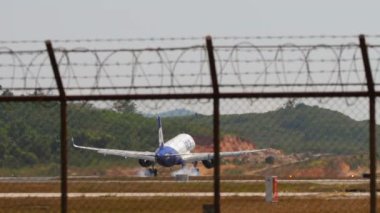 PHUKET, THAILAND - 15 Şubat 2023: Arka görüş, ticari Airbus A320, Go First iniş VT-WJO, Phuket havaalanına dokunma ve fren. Düşük maliyetli Hindistan Havayolları. Turizm ve seyahat kavramı