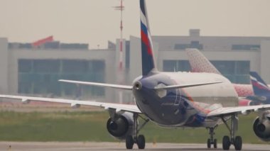 MOSCOW, Rusya Federasyonu - 28 Temmuz 2021: Airbus A320, Sheremetyevo havaalanı, yan görüş, orta çekim. Uçak taksisi, havaalanında sis...
