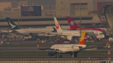BANGKOK, THAILAND - 01 Mart 2023: Airbus A319, Druk Air 'den A5-JSW Suvarnabhumi Havaalanı' na indikten sonra frenleme, yan görüş. Bir uçağın gelişinin sinematik görüntüleri. Gün batımında havaalanı