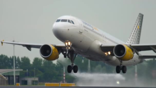 アムステルダム オランダ 2017年7月24日 エアバスA320 VuelingのEc Lobはアムステルダム空港で離陸します 出発だ 飛行機は シャーシとエンジンの下からのビューを飛ぶ 旅行のコンセプト — ストック動画