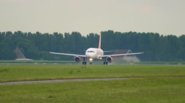 AMSTERDAM, NETHERLANDS - 24 Temmuz 2017: Airbus A320, Amsterdam Havalimanı 'ndan kalkmadan önce kolay jet hızlanmasının G-EZUL' u. Jetin kalkışının yan görüntüsü. Turizm ve seyahat kavramı