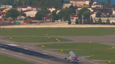 SOCHI, RUSSIA - 29 Temmuz 2022: Rossiya yolcu jeti Adler, Sochi havaalanından havalanıyor. Arka manzara, uçak kalkışı. Uçuş