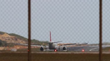 Fren yapan bir uçağın arka görüntüsü, flaplar yukarı. Yolcu uçağı geldi.