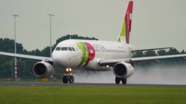 AMSTERDAM, NETHERLANDS - 24 Temmuz 2017: Airbus A319, TAP Air Portugal kalkışının CS-TTC 'si, Schiphol Havalimanı' na tırmanıyor. Uçak kalkıyor. Jet iniş takımlarını kapatıyor. Uçak ayrılıyor.