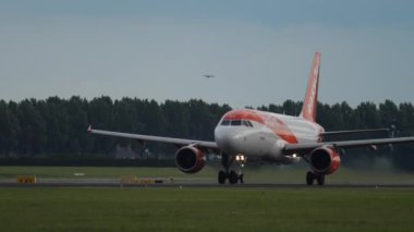 AMSTERDAM, NETHERLANDS - 24 Temmuz 2017: Commercial jet Airbus A320 of Easy Jet Amsterdam Havalimanı, yan görüş, orta çekim. Turizm ve seyahat kavramı