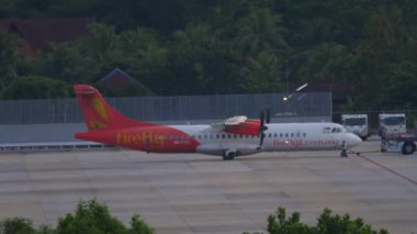 PHUKET, THAILAND - 27 Kasım 2019: Yolcu uçağı ATR 72-500, Phuket Havaalanında Firefly taksisi 9M-FYC. Çekici uçak. Tropik bir adada havaalanı