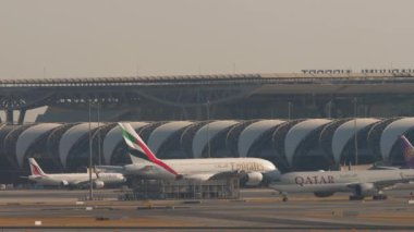 BANGKOK, THAILAND - 19 HAZİRAN 2023: Katar Havayolları 'nın geniş gövdeli Boeing 777 uçağı Suvarnabhumi Havaalanı' nda taksicilik yapıyor. Uçaklar terminale yanaştı.