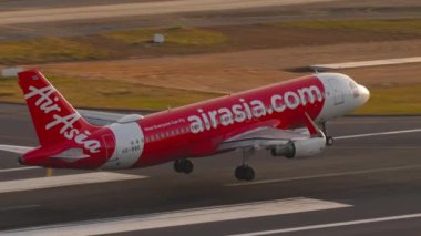 PHUKET, THAILAND - 11 Şubat 2023: Airbus A320, AirAsia 'dan HS-Bbe, Phuket Havaalanı' na iniş ve frenleme. Asya 'da ucuz havayolu. Uçak geliyor.