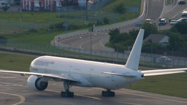 ロシア 2022年7月29日 ノルトウィンド航空のボーイング777型機 73340がアドラー空港の滑走路をタクシーで走っている 出発だ 背景の高速道路 — ストック動画