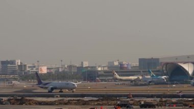 BANGKOK, THAILAND - 19 HAZİRAN 2023: Boeing 777, Tayland Havayolları 'ndan HS-TKK Suvarnabhumi Havaalanı' ndan havalanır. Geniş gövdeli uçak kalkışı. İkinci uçak paralel iniyor. Büyük havaalanı, genel bakış.