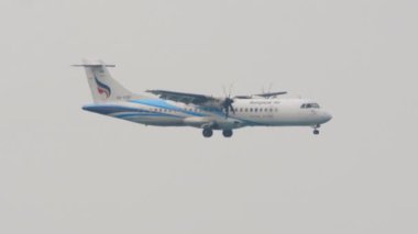 PHUKET, THAILAND - 25 Şubat 2023: Turboprop yolcu uçağı ATR 72-600, Bangkok Havayolları HS-PZF, Phuket Havaalanı, yan görüş. Gökyüzünde bir uçak. Seyahat kavramı