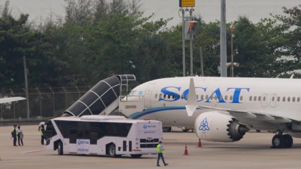 タイのプーケット 2023年2月25日 ボーイング737 Max アップB3727 Scat航空のエプロンプーケット空港 到着時に 航空機との階段のドッキング 乗客を待っている4月バス — ストック動画