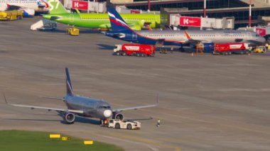 SOCHI, RUSSIA - 29 Temmuz 2022: Airbus A320, RA-73779 Aeroflot, Sochi pisti, uzak çekim. Traktör bir uçağı çekiyor. Uçaklar terminale yanaştı. Turizm ve seyahat kavramı