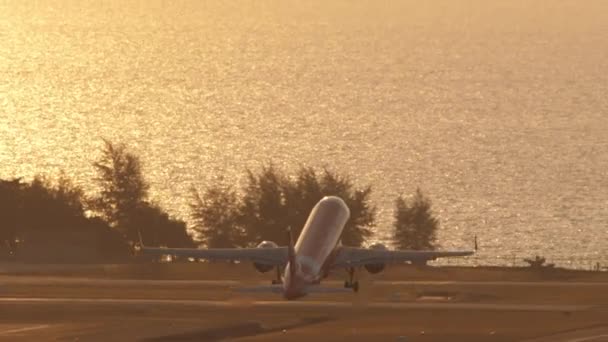 2023年2月11日 ジェット航空機Airasiaの撮影は バックライトで日没時に出発します アジアの格安航空会社を離れる 飛行機の登山 バックライトの輝く海 — ストック動画