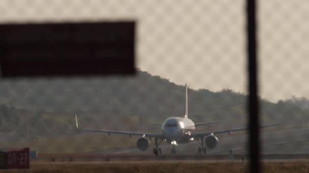 タイのプーケット 2023年2月10日 エアアジアのエアバスA320のフェンスを通して見る素晴らしい新しい章プーケット空港で離陸するLivery ジェット機の出発 観光と旅行のコンセプト — ストック動画