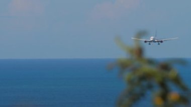 Uçaklar denizden havaalanına iniyor. Yaklaşan bir jet görüntüsü. Adaya uçak geliyor. Turizm ve seyahat kavramı