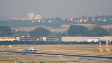 İndikten sonra fren yapan bir uçak görüntüsü. Uçak iniyor. Havaalanında yolcu uçuşu, yan görüş