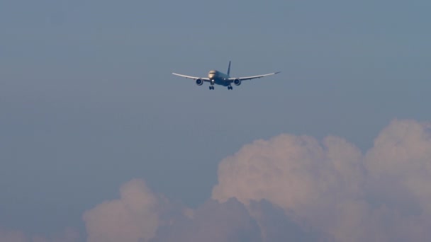 着陸前に接近するジェット航空機 フロントビュー 乗客用飛行機は青空に飛びます 降下中の航空会社の長いショット 観光と旅行のコンセプト — ストック動画