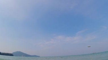 PHUKET, THAILAND - FEBRUARY 24, 2023: Civil aircraft of Azur Air flies over the beach. Passenger airliner landing over the sea in Phuket airport. Mai Khao tourist beach in Thailand