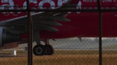 PHUKET, THAILAND - 26 HAZİRAN 2023: Phuket havaalanı pistine taksicilik yapan düşük maliyetli havayolu havayolu yan görüntüsü. Havaalanında bir uçak var. Yolcu uçuşu