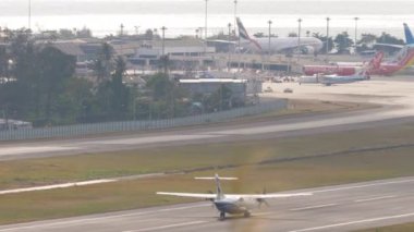 PHUKET, THAILAND - 11 Şubat 2023: Turboprop uçak ATR 72 Bangkok Havayolları Phuket Havaalanı 'nda kalkışa hazırlanıyor. Yolcu uçağı kalkış, uzak çekim, dikiz manzaralı.