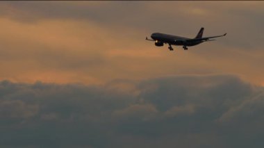 PHUKET, THAILAND - HAZİRAN 03, 2023: Phuket Havaalanına inen bir Aeroflot yolcu uçağının sinematik görüntüleri. Bulutlu, güzel gün batımı, gökyüzünde bir uçak. Turizm ve seyahat kavramı