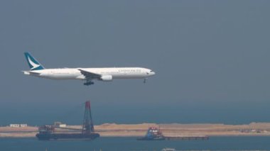 HONG KONG - 10 Kasım 2019: Cathay Pacific 'in Boeing 777 uçağı Hong Kong havaalanına iniyor. Yolcu uçağı geliyor. Geniş gövde alçalıyor, kenar görünüm