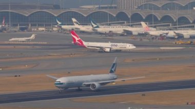 HONG KONG - 10 Kasım 2019: geniş gövdeli Boeing 777 Cathay Pacific 'in Chek Kap Kok Havalimanı' ndan kalkış görüntüleri. Yolcu uçağı kalkıyor. Uçaklar terminale yanaştı.