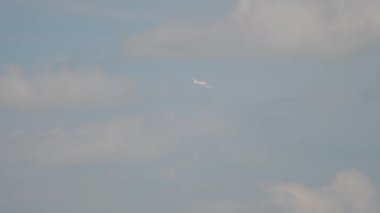 Bulutlu bir gökyüzünde bir uçağın düşmesi. Geçmişi bulanık, bulanık. Jet uçağı bulutların içinde kayboldu.