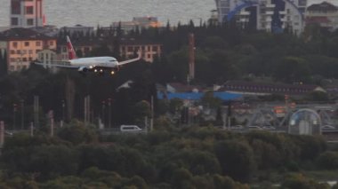 SOCHI, RUSSIA - 28 Temmuz 2022: Boeing 737 Nordwind yolcu uçağı Sochi havaalanına indi, gün batımı veya şafak vakti. Uçak geliyor, yan görüş. Turizm ve seyahat kavramı