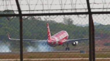 PHUKET, THAILAND - 10 Şubat 2023: Airbus A320, HS-BBD AirAsia iniş ve frenleme Phuket havaalanı, arka görüş. Yolcu uçağı geliyor. Turizm seyahati kavramı
