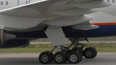 Yolcu uçağı kalkıyor, yakın plan. Şasenin ve pencerenin yan görünümü