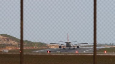 Fren yapan bir uçağın arka görüntüsü, spoiler veriliyor. Yolcu uçağı geldi. Havaalanının arkasındaki uçak.