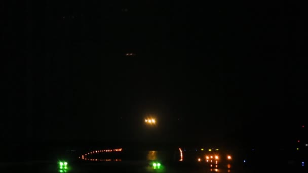 夜に飛行機が着陸する ランウェイはランディングライトで照らされます — ストック動画