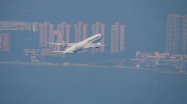 HONG KONG - 09 Kasım 2019: Japon Hava Yolları Boeing 777 Hong Kong havaalanından havalanıyor ve tırmanıyor. Yolcu uçağı kalkıyor