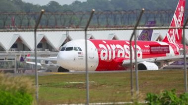 PHUKET, THAILAND - 27 Kasım 2015: AirAsia 'dan Lowcoster Airbus A320 Phuket havaalanında pistte taksicilik yapıyor. Taksideki uçaklar. Turizm seyahati kavramı