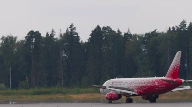 MOSCOW, Rusya Federasyonu - 29 Temmuz 2021: Uçak Sukhoi Superjet 100, Rossiya 'nın RA-89114' ü Sheremetyevo havaalanına indikten sonra fren yapıyor, yan görüş. Seyahat havacılık kavramı