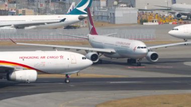 HONG KONG - 10 Kasım 2019: yan görüş, Airbus A330 Hong Kong Havaalanı 'nda taksicilik. Taksideki uçaklar. Yoğun hava trafiği. Ayrılmak için kuyruk