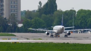 ALMATY, KAZAKHSTAN - 4 Mayıs 2019: çekici yolcu uçağı. Airbus A320, Air Astana 'nın P4-KBD' si Almaty Havaalanı, yan görüş. Bir yaz günü havaalanında. Avia trafiği