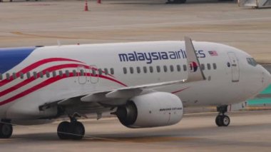 PHUKET, THAILAND - 25 Şubat 2023: Phuket havaalanında taksicilik yapan Malezya Havayolları 'ndan Boeing 737, 9M-MLT. Havaalanındaki uçak. Pistteki uçak görüntüsü. Seyahat kavramı