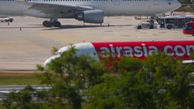 PHUKET, THAILAND - 26 Kasım 2016: AirAsia yolcu uçağı pistte. Asya Havayolları A320 Phuket Havaalanı 'ndan kalkmaya hazır.