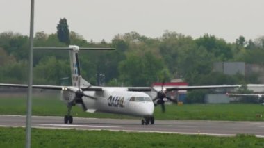 ALMATY, KAZAKHSTAN - 4 Mayıs 2019: De Havilland Canada Dash, Kazaq Air 'in P4-NUR kalkışı, uçuşu, tırmanışı, tırmanışı, dikiz görüntüsü. Turboprop yolcu uçağı