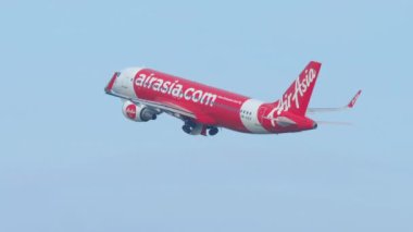 PHUKET, THAILAND - 3 Aralık 2018 Airbus A320, AirAsia 'dan HS-BBI, Phuket havaalanında kalkış ve tırmanış, yan görüş. Gökyüzünde bir uçak. Yolcu uçağı kalkıyor