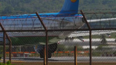 PHUKET, THAILAND - 10 Şubat 2023: Airbus A321, UK32103 Özbekistan Havayolları Phuket havaalanından kalkış için hızlanıyor, çitten arka görüş